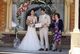 Sylvie posing with the bride and groom as they hold up their certificate in front of the alter.