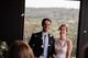 The bride and groom smiling while flower petals are being thrown in the air.